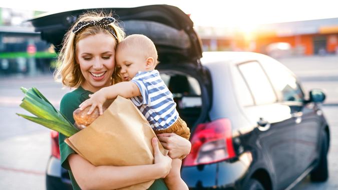 Young mother with baby boy in front of a supermarket. stock photo