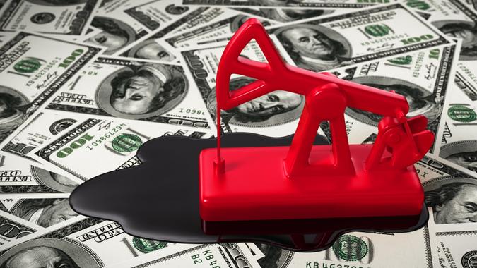 Red Pumpjack And Spilled Oil On The Money stock photo