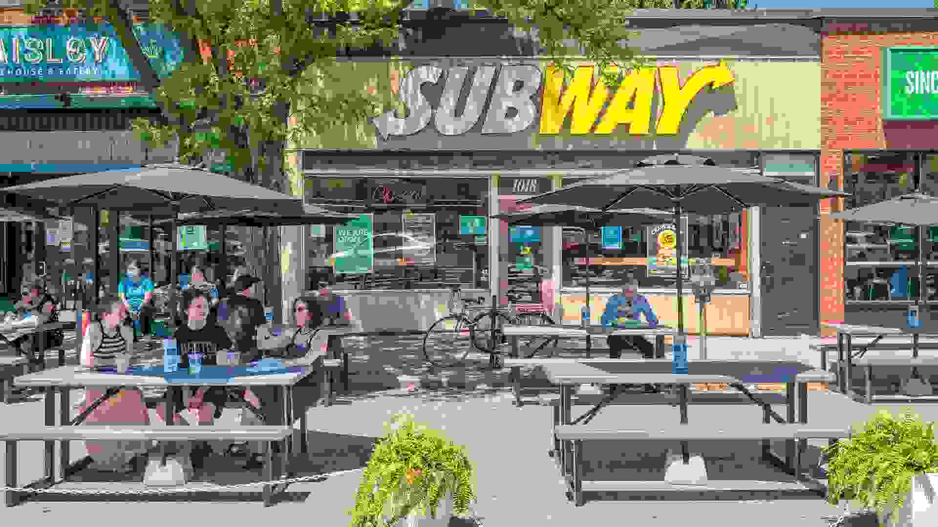 People eat outdoors on fast-food restaurant patio stock photo