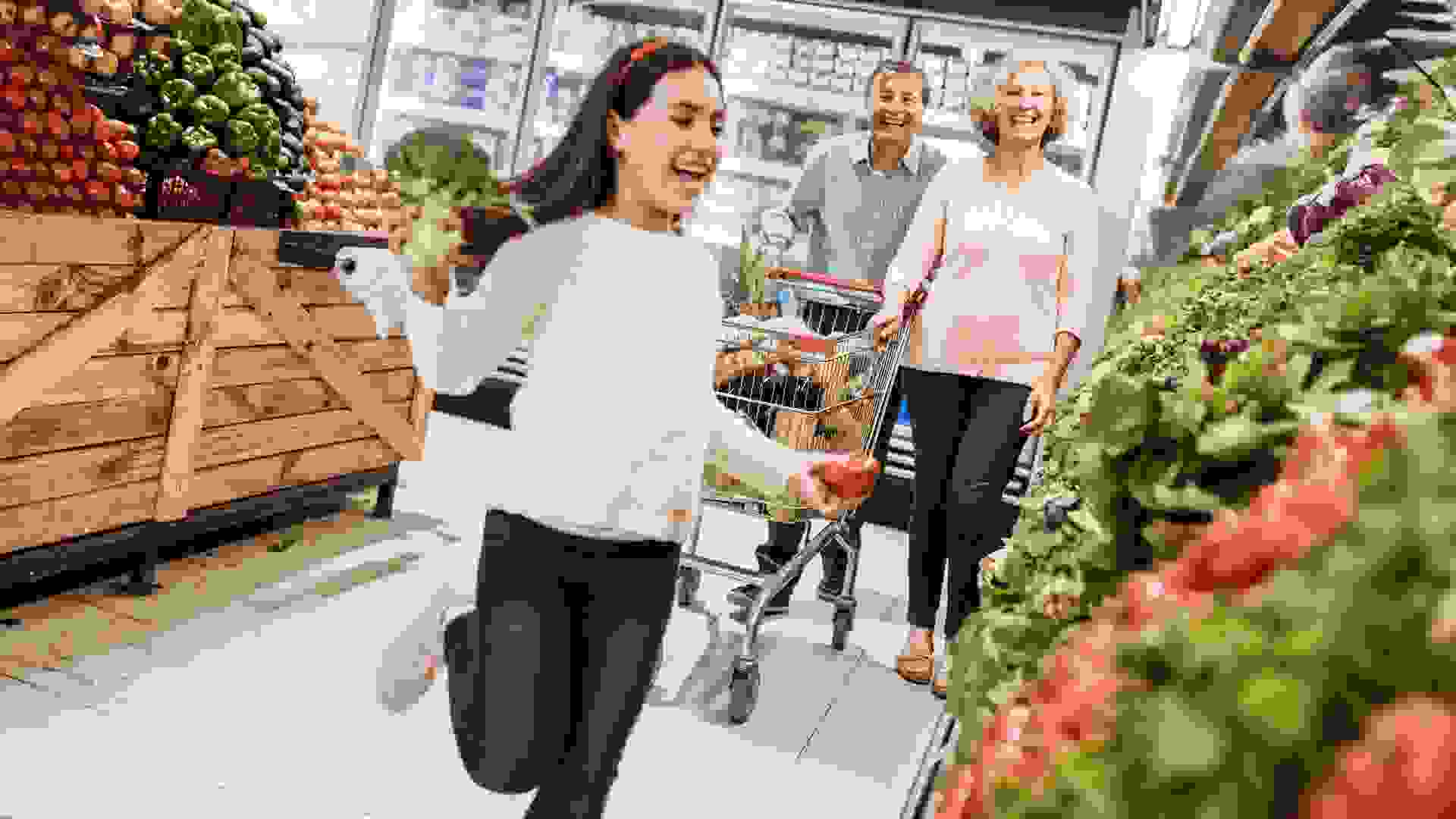 Seniors going shopping - grandparents with grandchild in supermarket stock photo