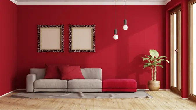 Red living room with modern sofa and old frame on wall - 3d renderingthe room does not exist in reality, Property model is not necessary.