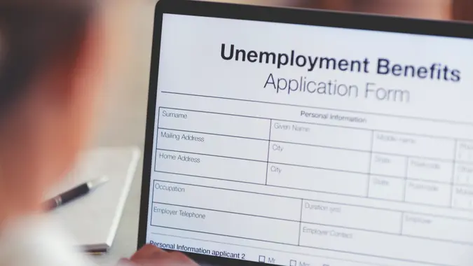 Woman filling out an online unemployment benefits application form.