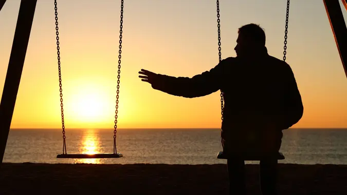 Man alone missing her partner at sunset stock photo