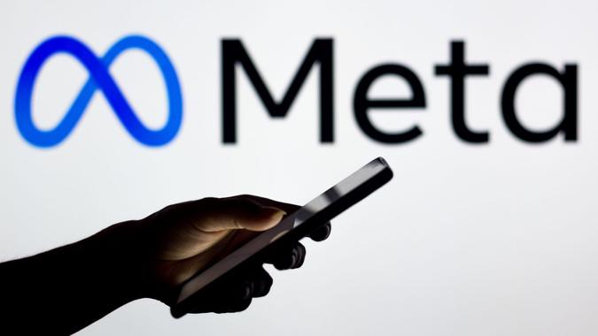 Mandatory Credit: Photo by Rafael Henrique/SOPA Images/Shutterstock (12852970i)In this photo illustration the Meta Platforms logo seen in the background of a silhouette woman holding a mobile phone.