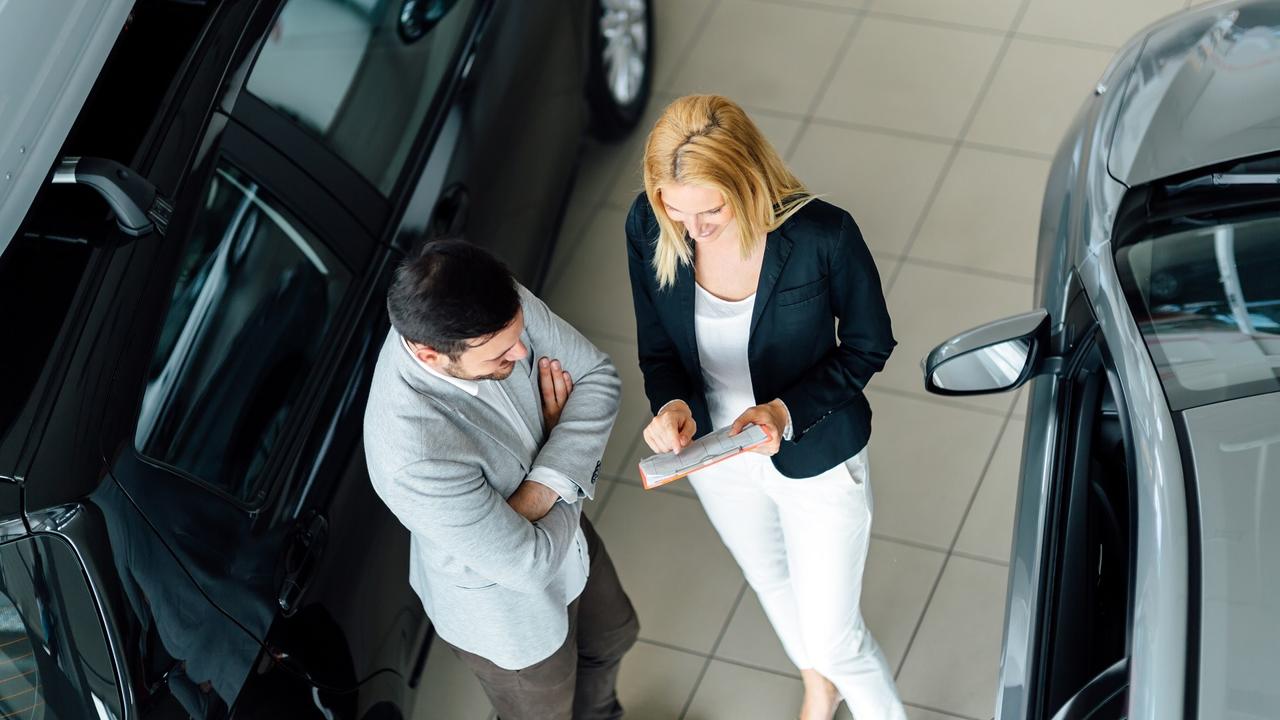 Salesperson showing vehicle to potential customer stock photo