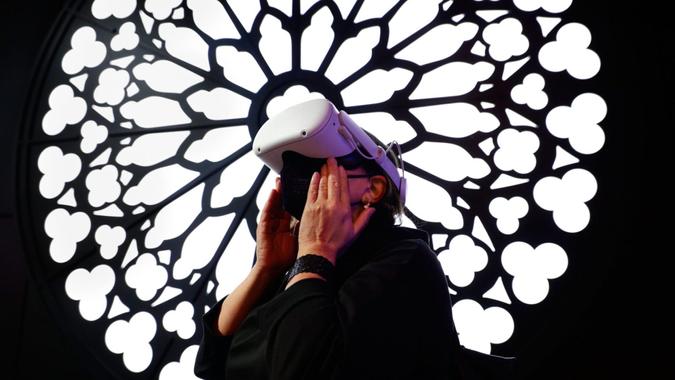 Mandatory credit: Photography by Joan Cros/NurPhoto/Shutterstock (12838942n) A conference attendee visits Notre Dame de Paris with a Meta Oculus Quest 2 headset on a virtual reality tour of the Orange Pavilion during the largest Mobile World Congress (MWC) industry trade fair celebrated Which focuses on mobile devices, 5G, IOT, AI and big data, on March 3, 2022 in Barcelona, ​​Spain.