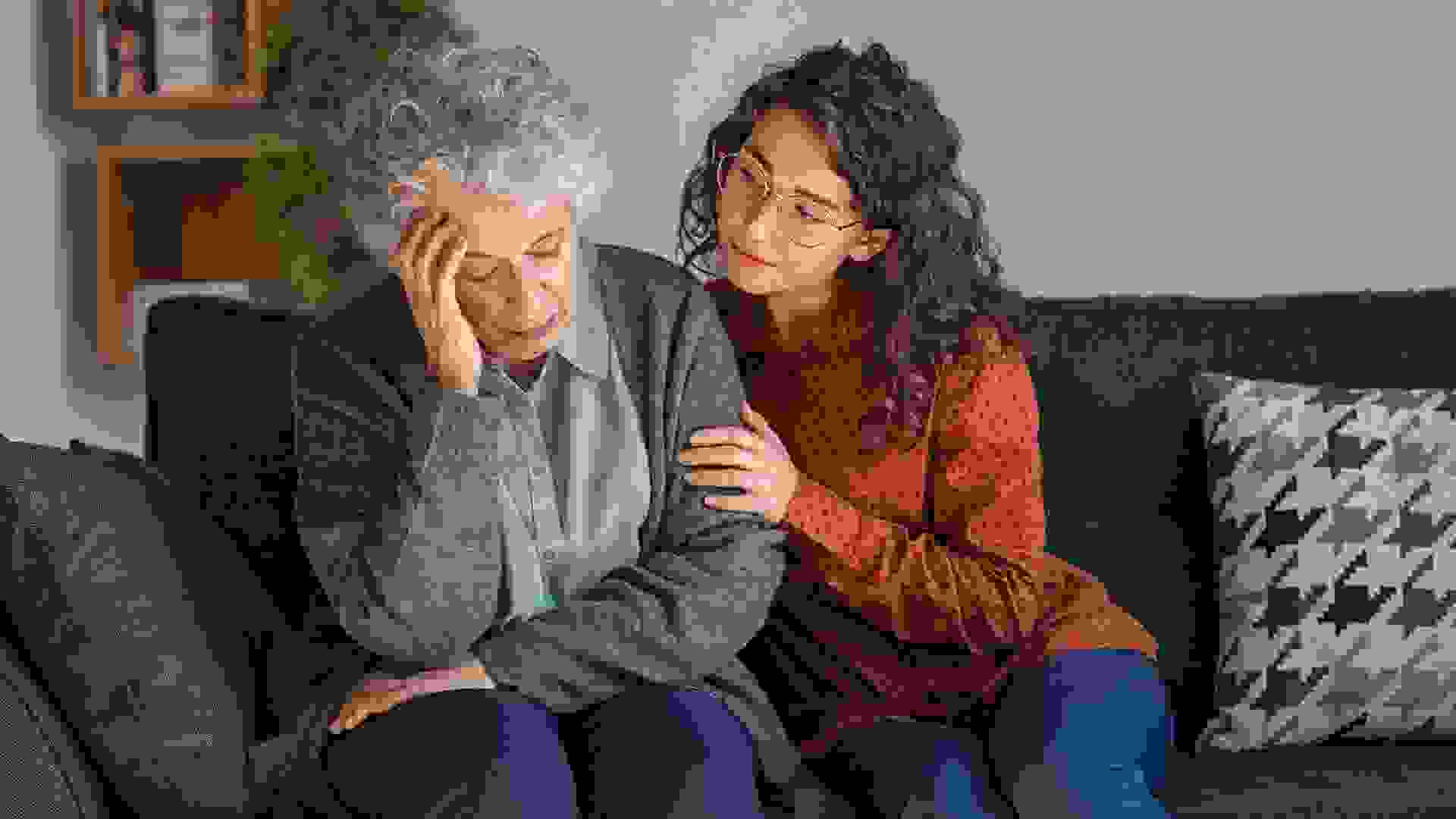 Young woman consoling upset grandmother stock photo