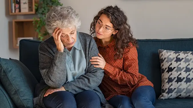 Young woman consoling upset grandmother stock photo
