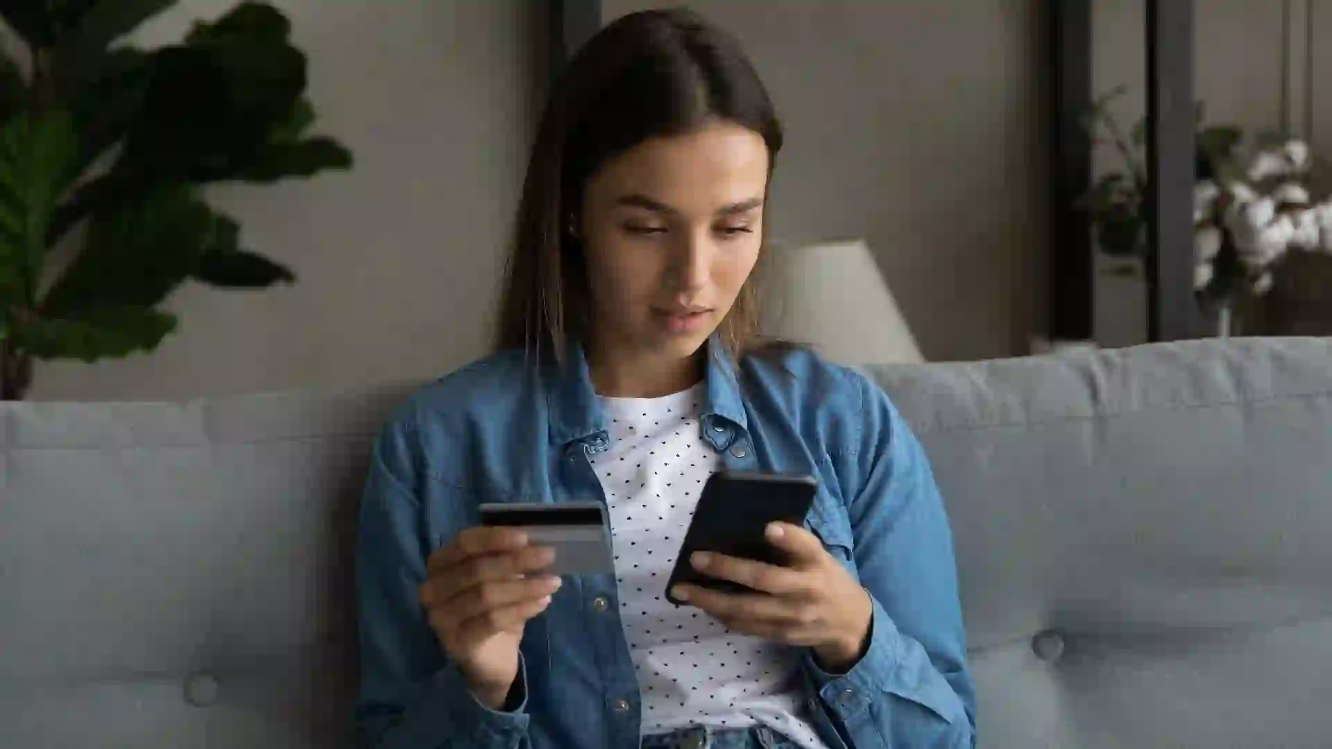Focused young lady check card account balance at phone app stock photo