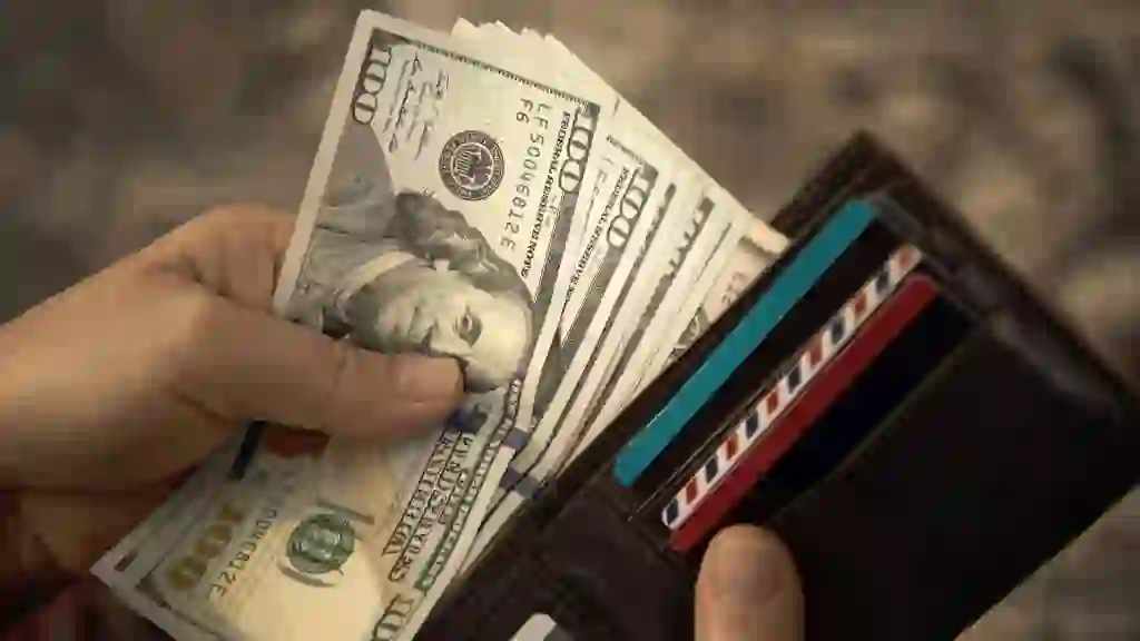 High angle view of unrecognizable mature man placing USA Dollar bills into wallet stock photo