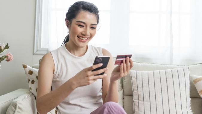 Happy asian woman using smartphone shopping online with credit card. Lifestyle. Easy pay using smart phone or digital device. stock photo