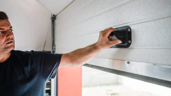 man opens pvc garage door manually.