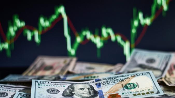 US dollar bills on background with dynamics of exchange rates.