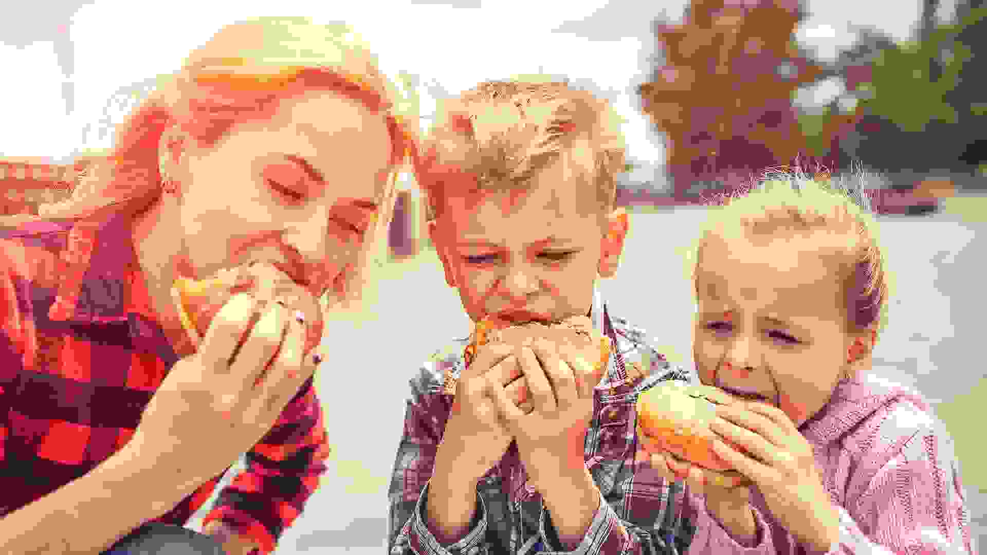 Family eating a hamburger outdoors  .