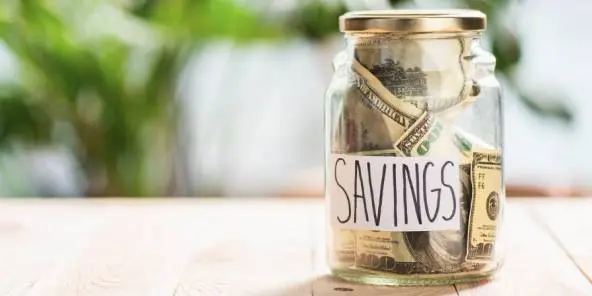 Jar full of money marked with the word savings