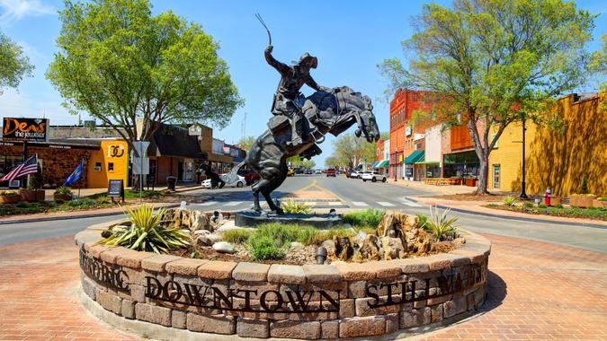 Stillwater, Oklahoma, USA - April 24, 2018: Daytime view of the enlarged bronze replica of 'The Bronco Buster' by famed sculptor Frederic Remington in a roundabout on Main Street in Stillwater Oklahoma.