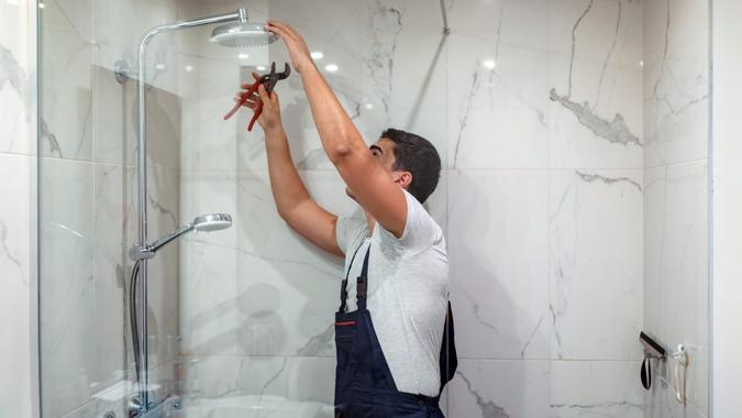 plumber at work in a bathroom, plumbing repair service, assemble and install concept.