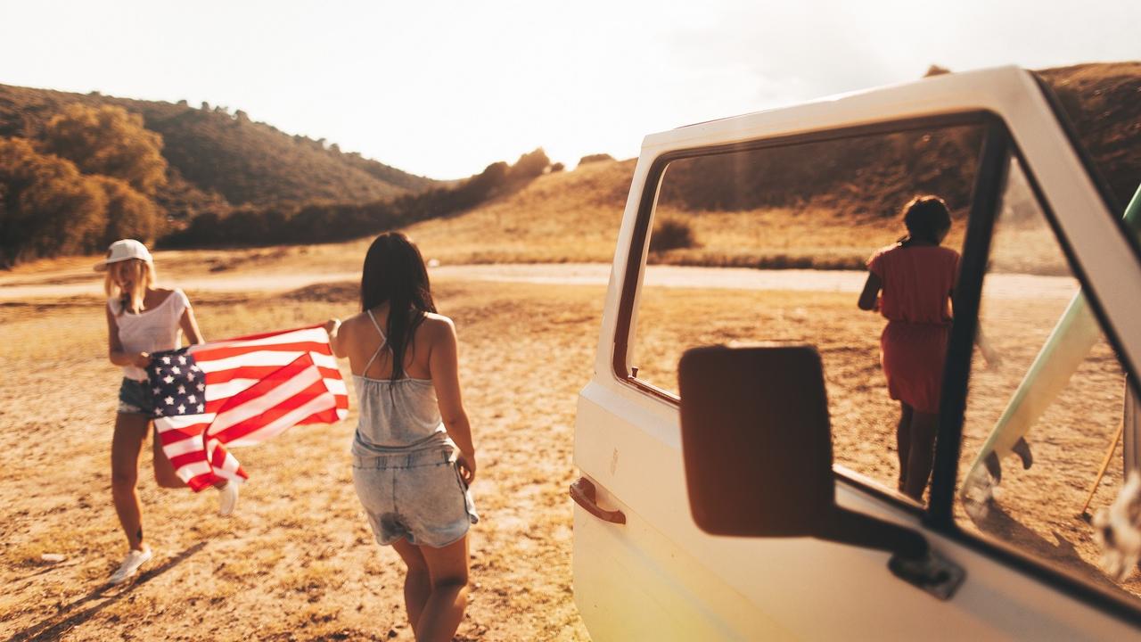 Two girlfriends taking a trip on Fourth of July stock photo