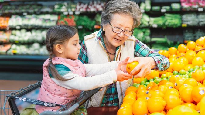 Senior woman takes her granddaughter grocery shopping. stock photo