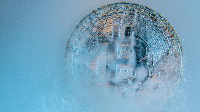 Prague, Czech Republic - October 2019: Silver Bitcoin, bitcoins online digital currency frozen in the blue ice.