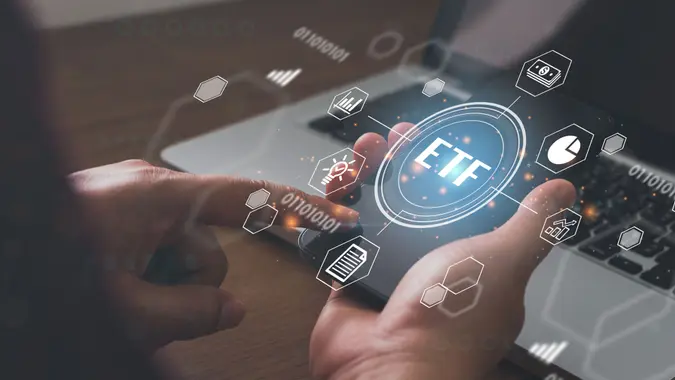 Businessmen holding a smartphone with icons of ETF Exchange traded fund stock market trading investment financial concept.