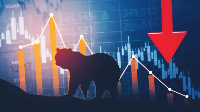 Silhouette of bear walking with declining finance chart and stock market background.