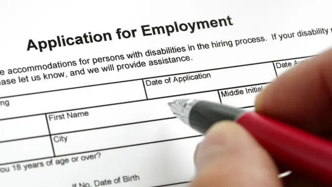 Completing a job application form with focus on heading.