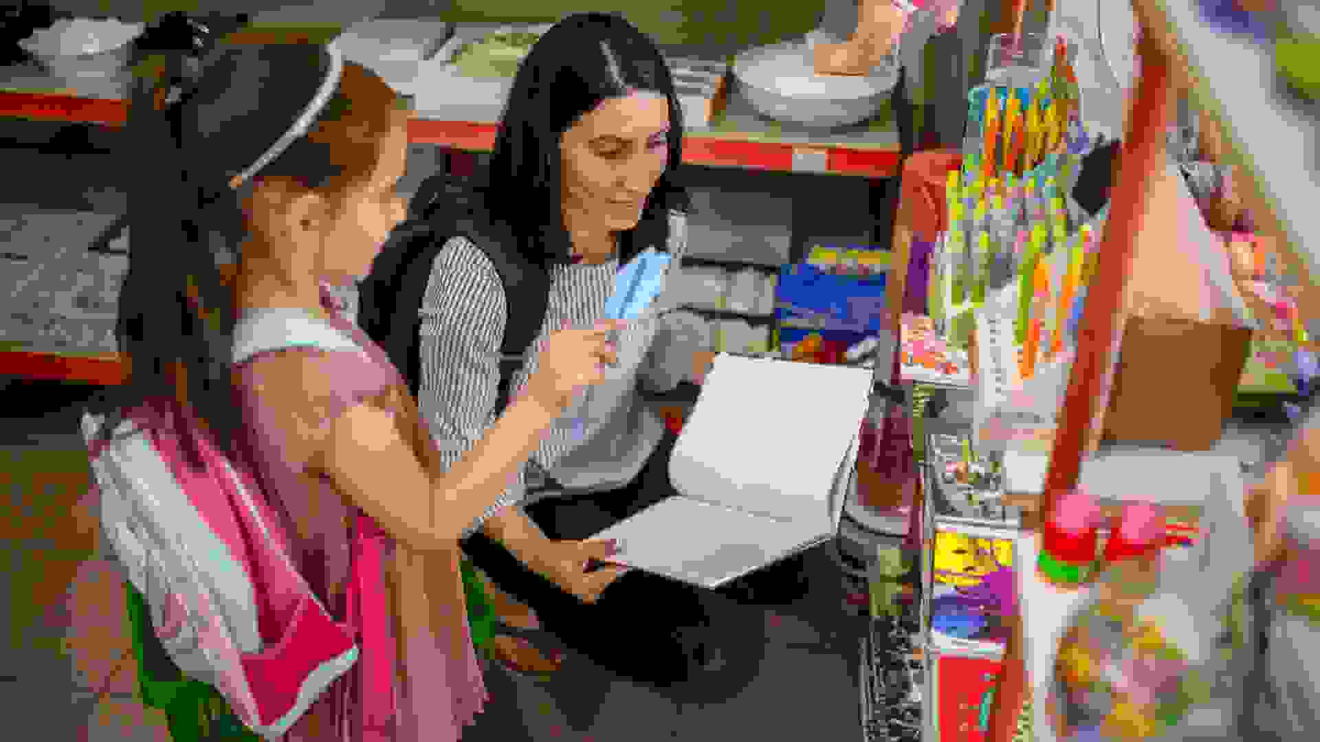 Caring mother helping her daughter to choose and buy all the essential school supplies stock photo