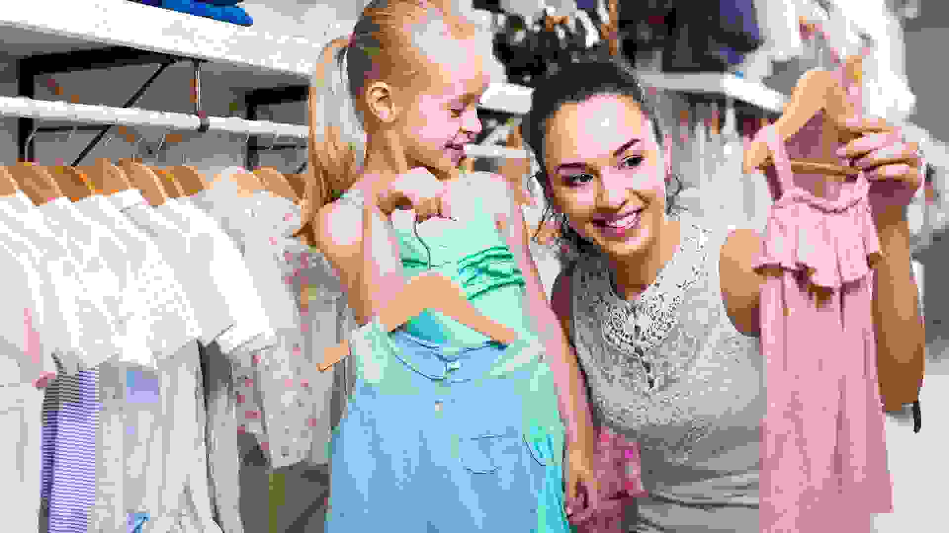 Portrait of woman and girl shopping kids apparel in clothes store stock photo