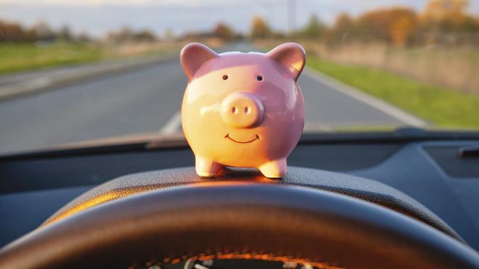 Piggy Bank sitting on the dashboard during driving a car stock photo