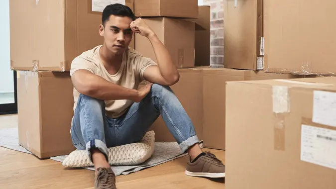 Shot of a young man being upset while sitting on the floor at home stock photo