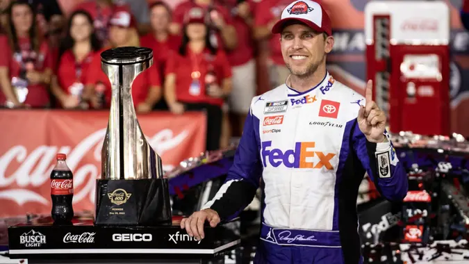 Mandatory Credit: Photo by Matt Kelley/AP/Shutterstock (12963641ab)Denny Hamlin smiles in Victory Lane after winning a NASCAR Cup Series auto race at Charlotte Motor Speedway, in Concord, N.