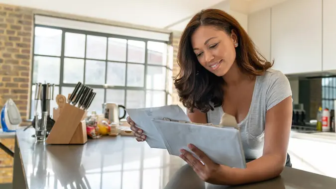 Beautiful woman at home checking the mail stock photo