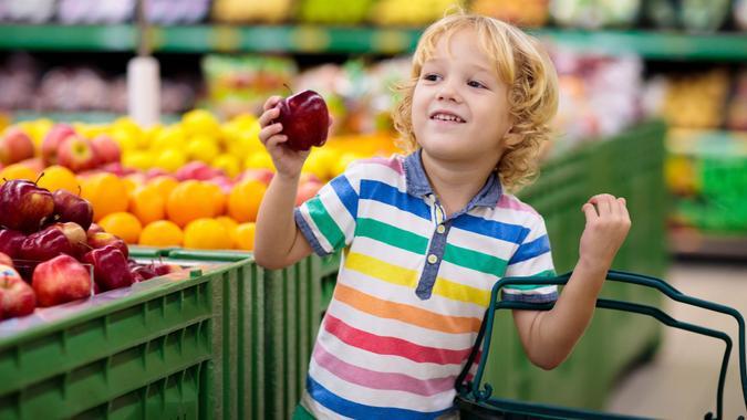 Child in supermarket. Kid grocery shopping. stock photo