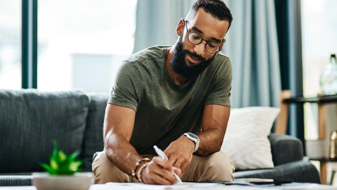 Shot of a young man going through his finances at home.