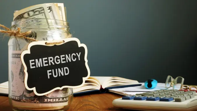 Emergency fund savings written on the jar with money.
