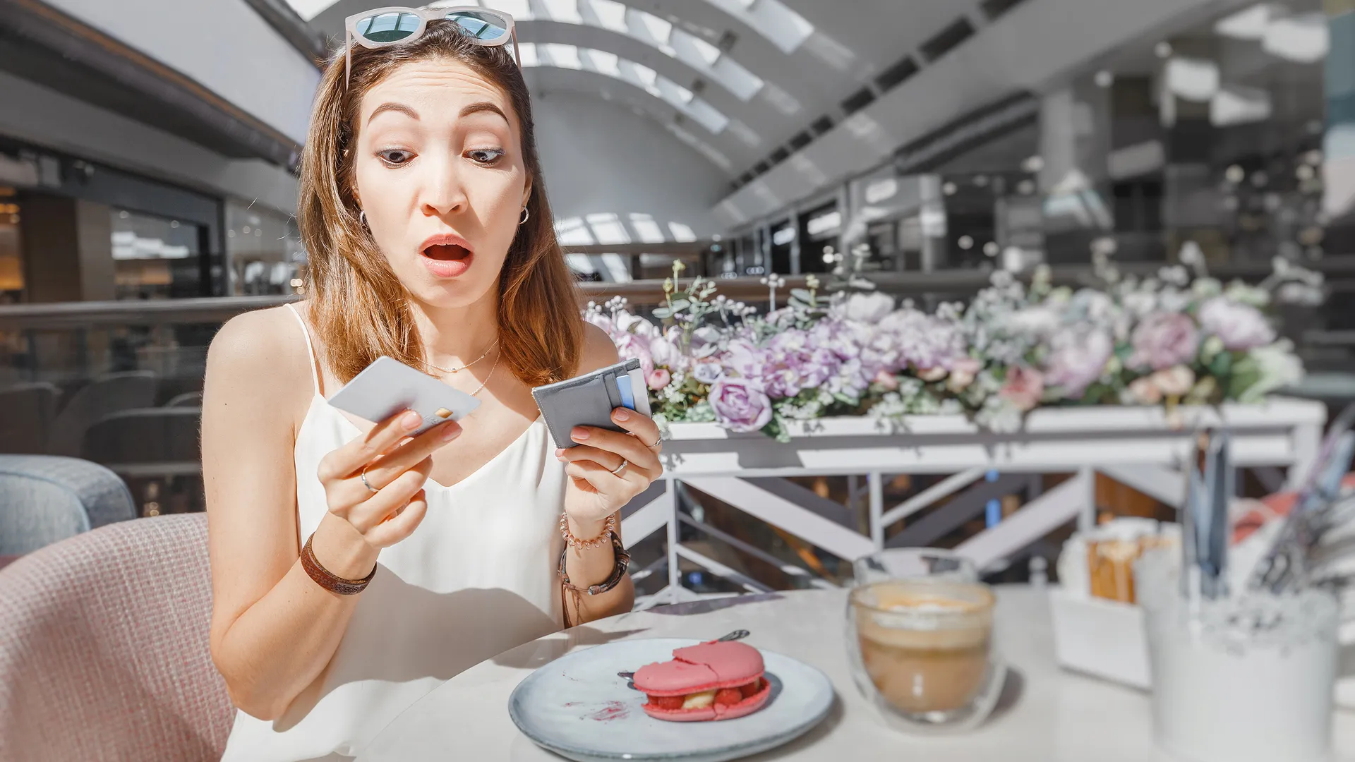 Puzzled girl thinking how to pay for breakfast in a cafe - by a credit card or cash.