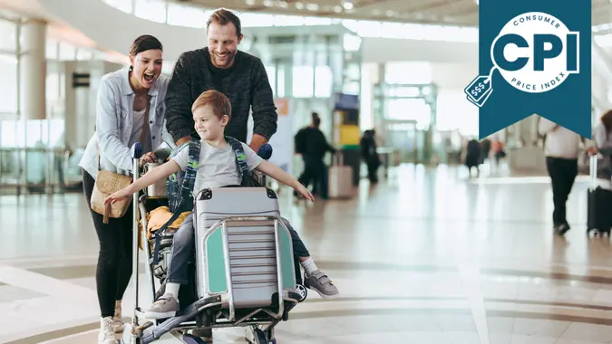 Couple happily pushing the trolley with their son at airport.