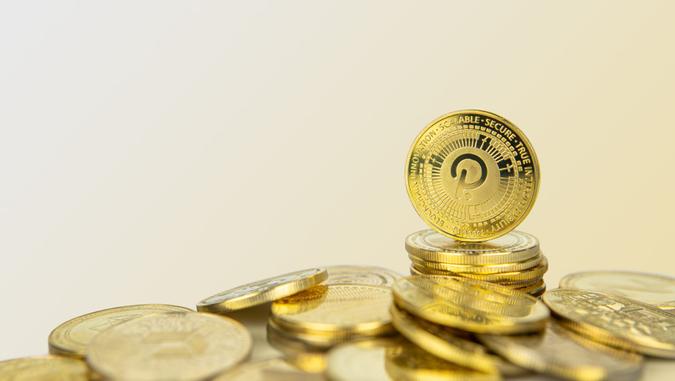 Polkadot or Dot cryptocurrency standing on pile of gold crypto coins with copy space.