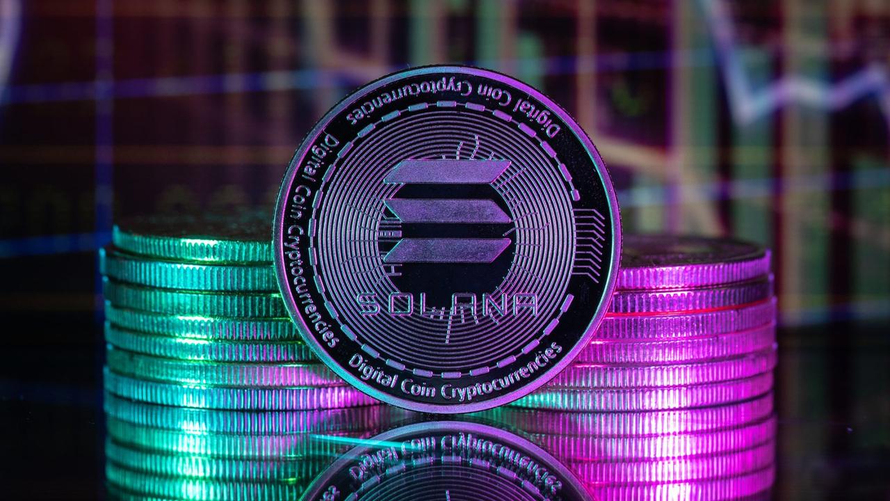 Solana SOL cryptocurrency physical coin and blurry price charts.