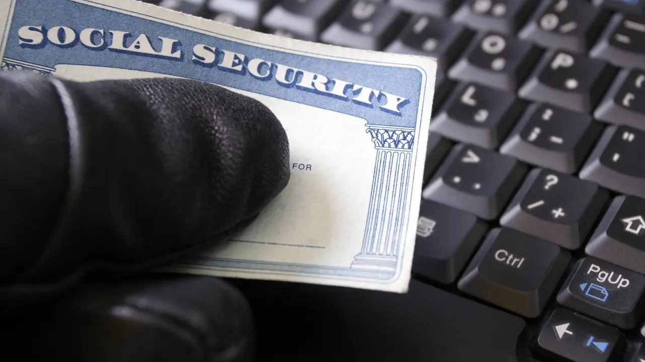 Man's hand holding Social Security card.