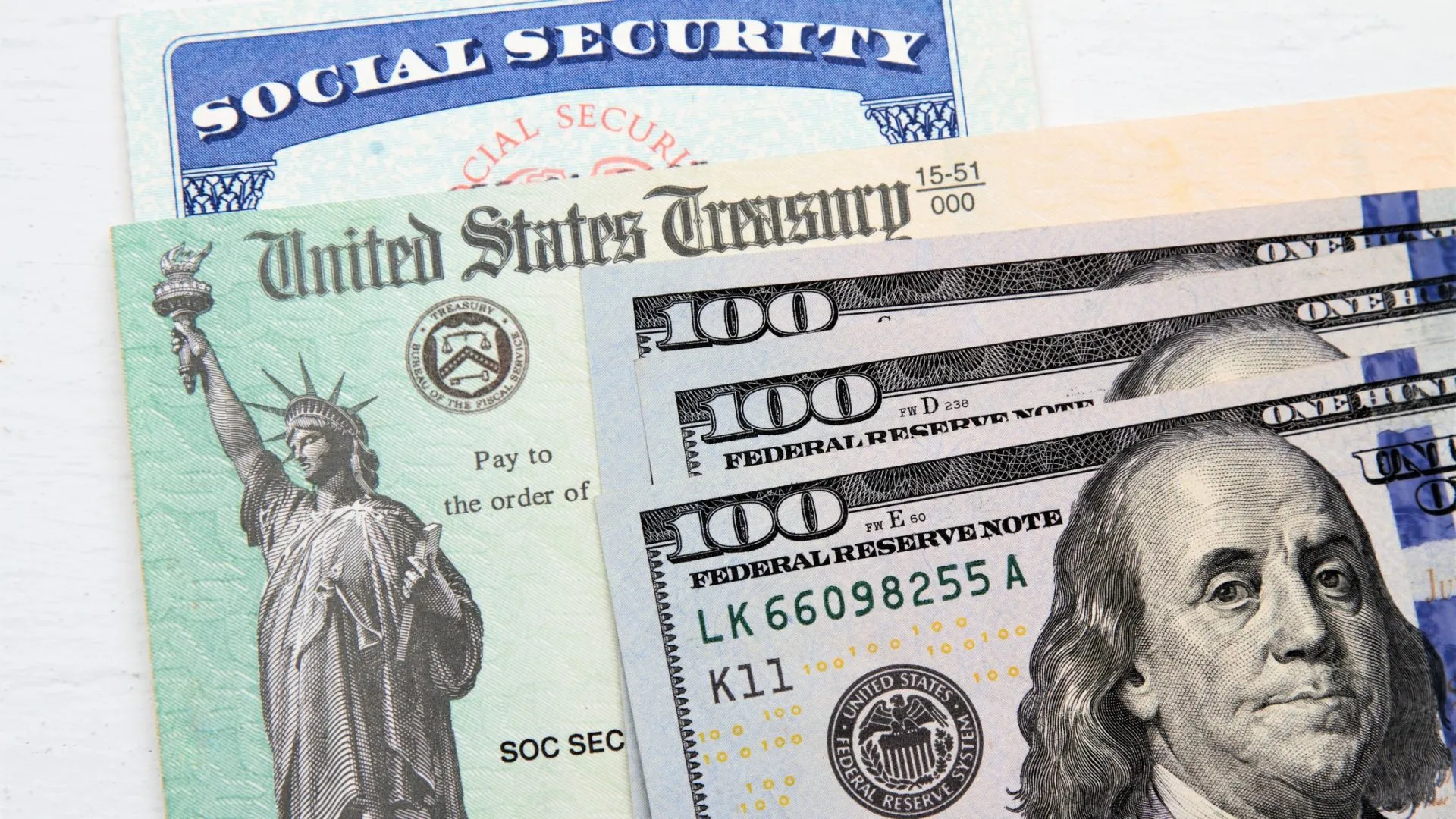部分视图的社会保障卡，美国财政部支票和百美元钞票。