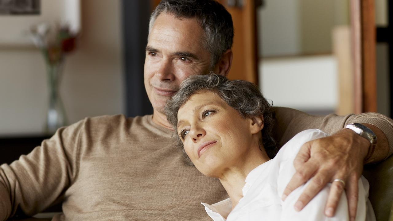 Thoughtful mature couple relaxing on sofa stock photo