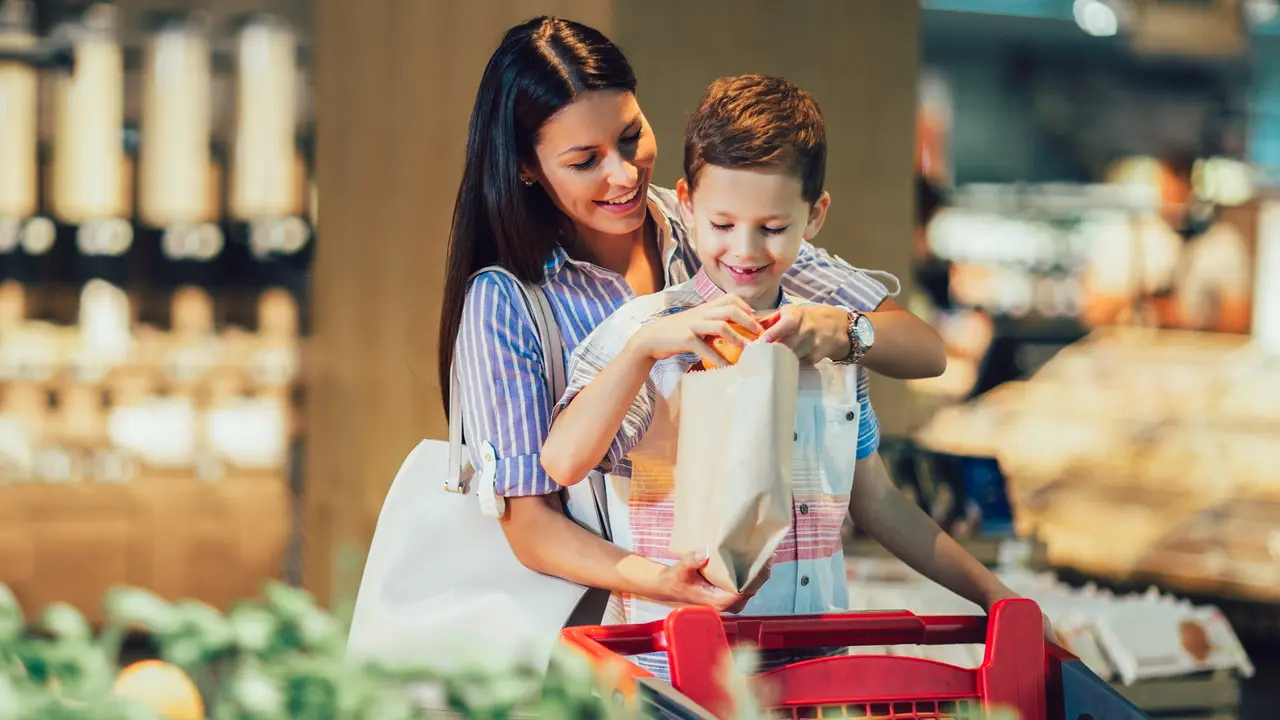 Mother and son buying fruit at grocery store or supermarket stock photo