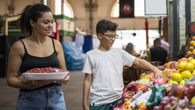 Mother and son buying fruits at the municipal market stock photo