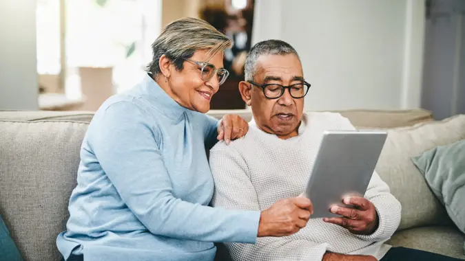 Stock image of a senior couple using a digital tablet at home.