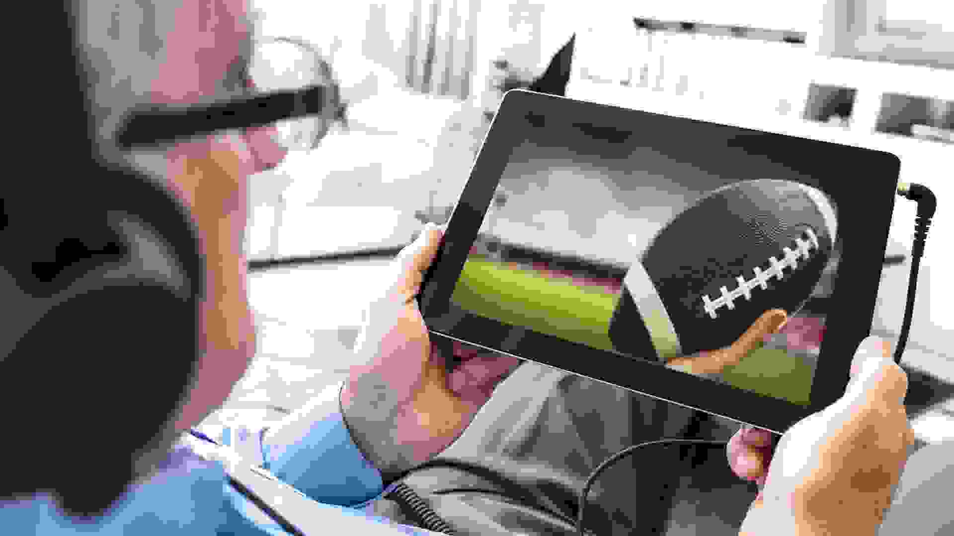 Man watching a football game on the tablet stock photo