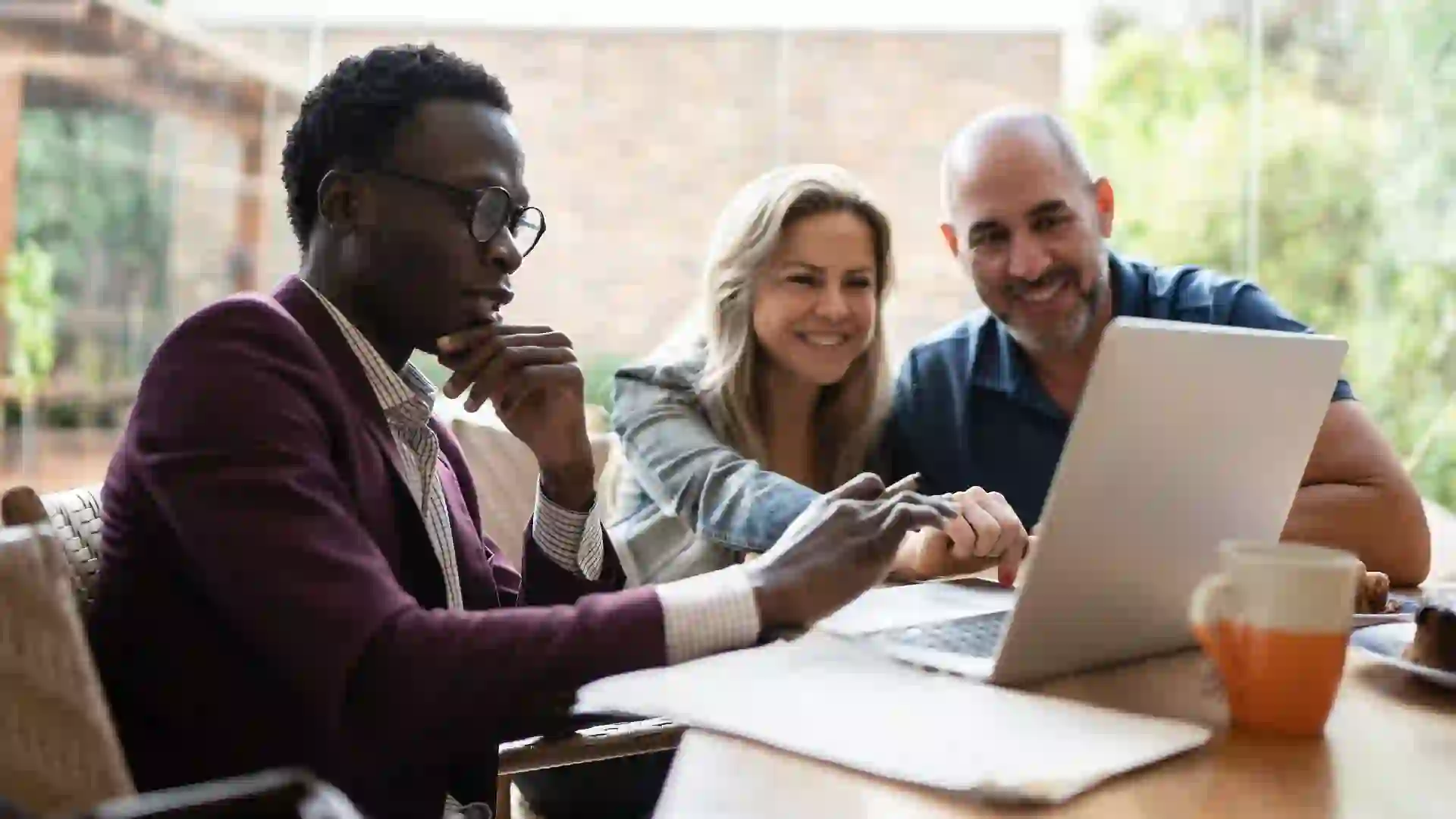 Real estate agent or finance advisor doing a meeting with couple at home stock photo