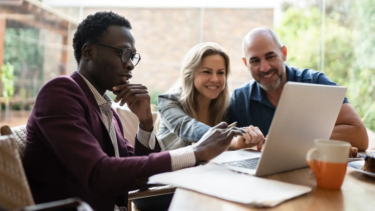 Real estate agent or finance advisor doing a meeting with couple at home stock photo