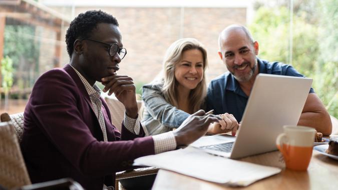 Real estate agent or finance advisor doing a meeting with couple at home stock photo